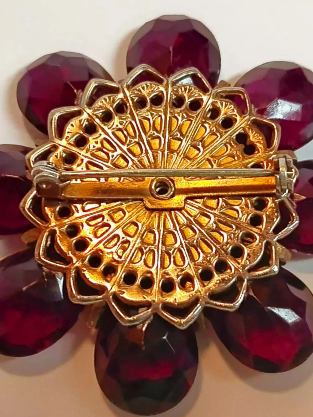 Vintage ruby lucite brooch with aurora borealis central rhinestone.